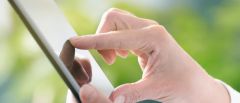 This image shows a woman operating a tablet via the touch screen.