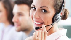 A woman talking on the phone through a headset.