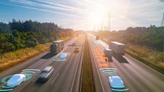 This image shows an autonomous self-driving vehicle on the highway with a graphic sensor radar signal system.